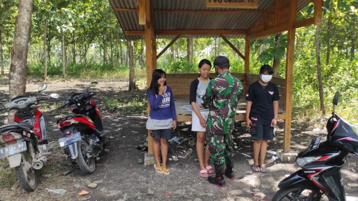 Anggota Satuan Tugas TMMD Bojonegoro Terapkan Protokol Kesehatan, Anak Anak Diberi Masker